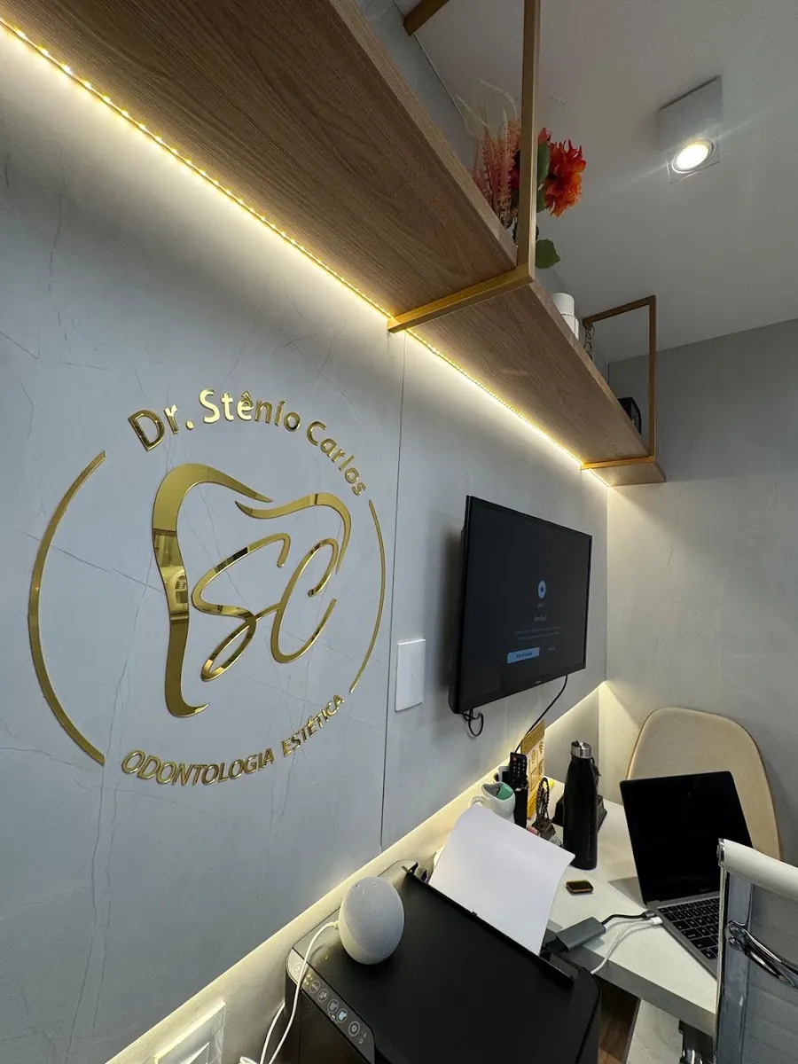 Logotipo dourado do Dr. Stênio Carlos na parede do consultório