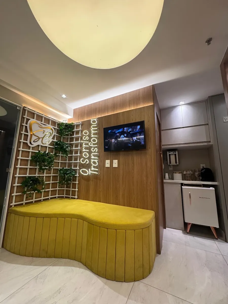 Recepção com sofá amarelo e a frase O sorriso transforma